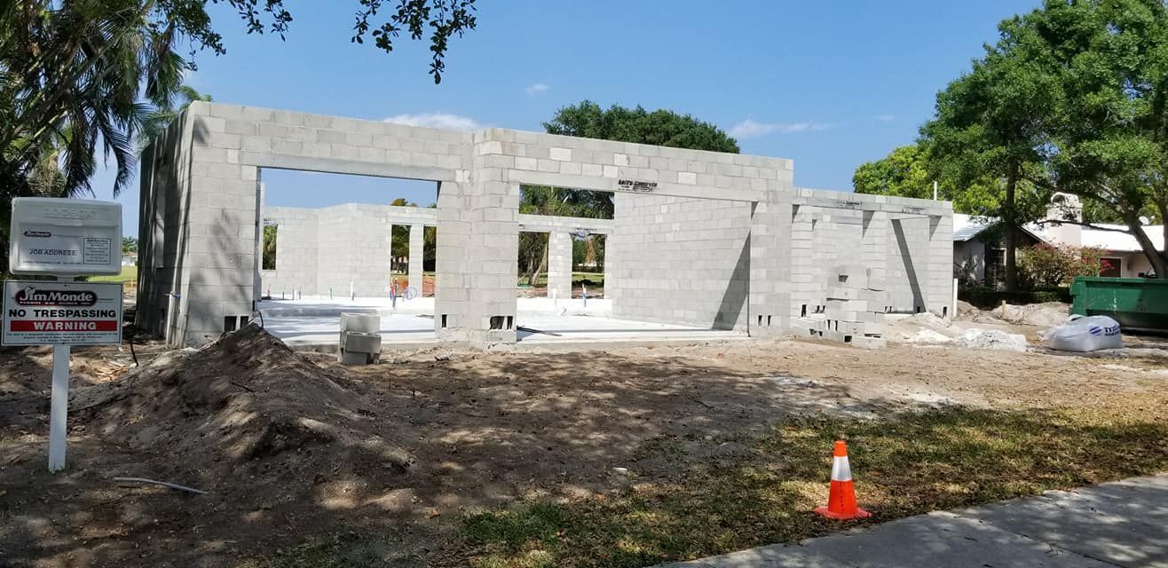 A house is being built in the middle of a dirt field.
