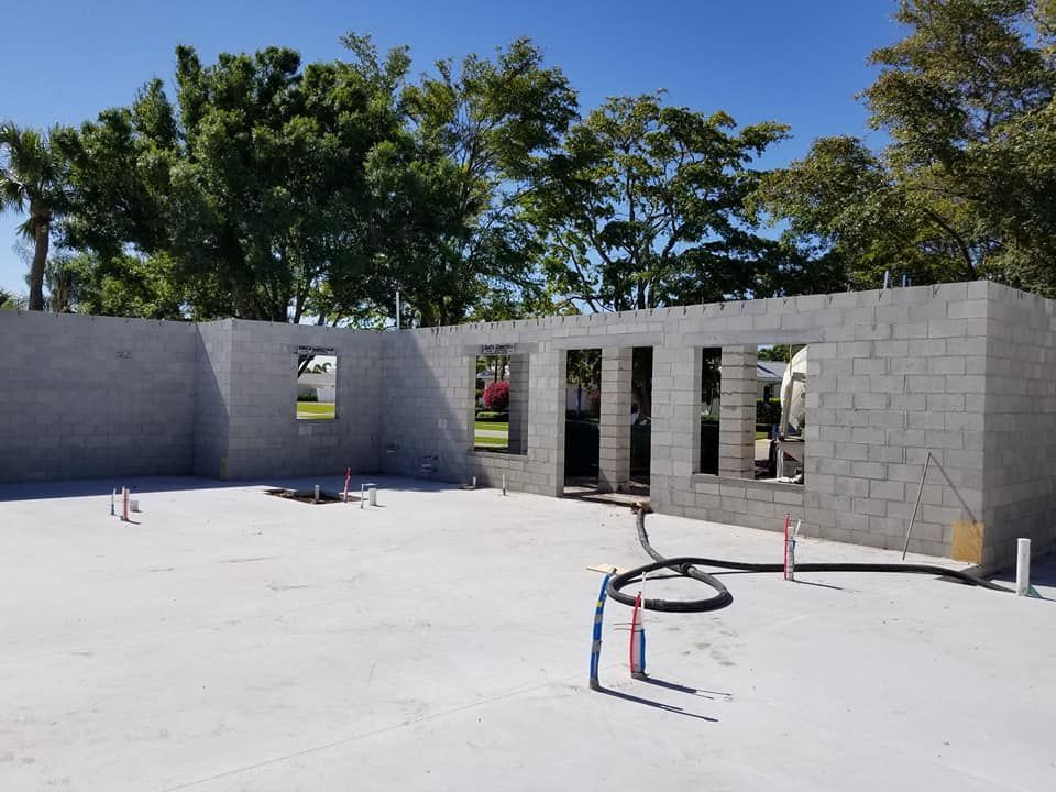 A brick building under construction with trees in the background
