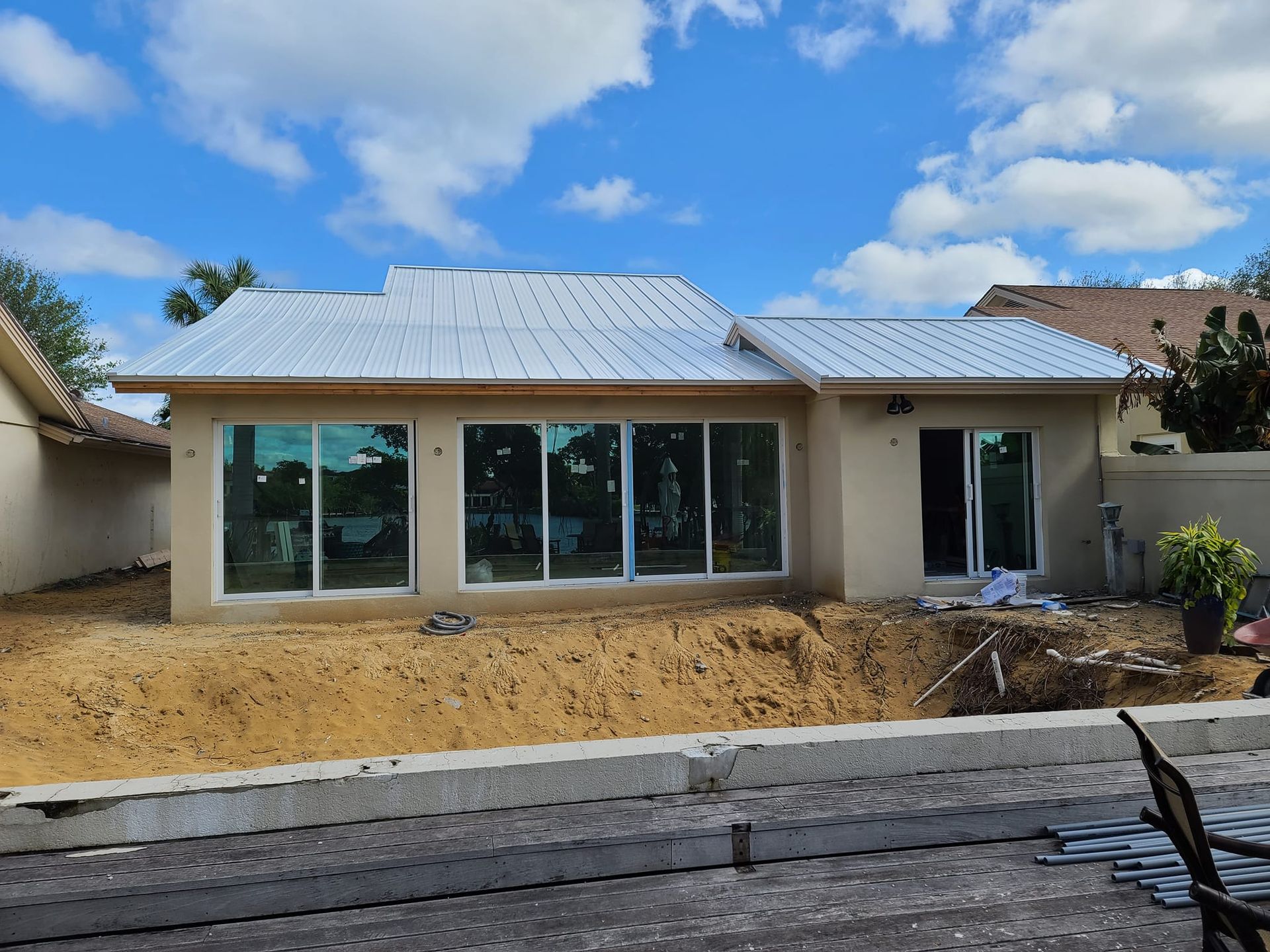 A house with a white roof and a lot of windows is being built.