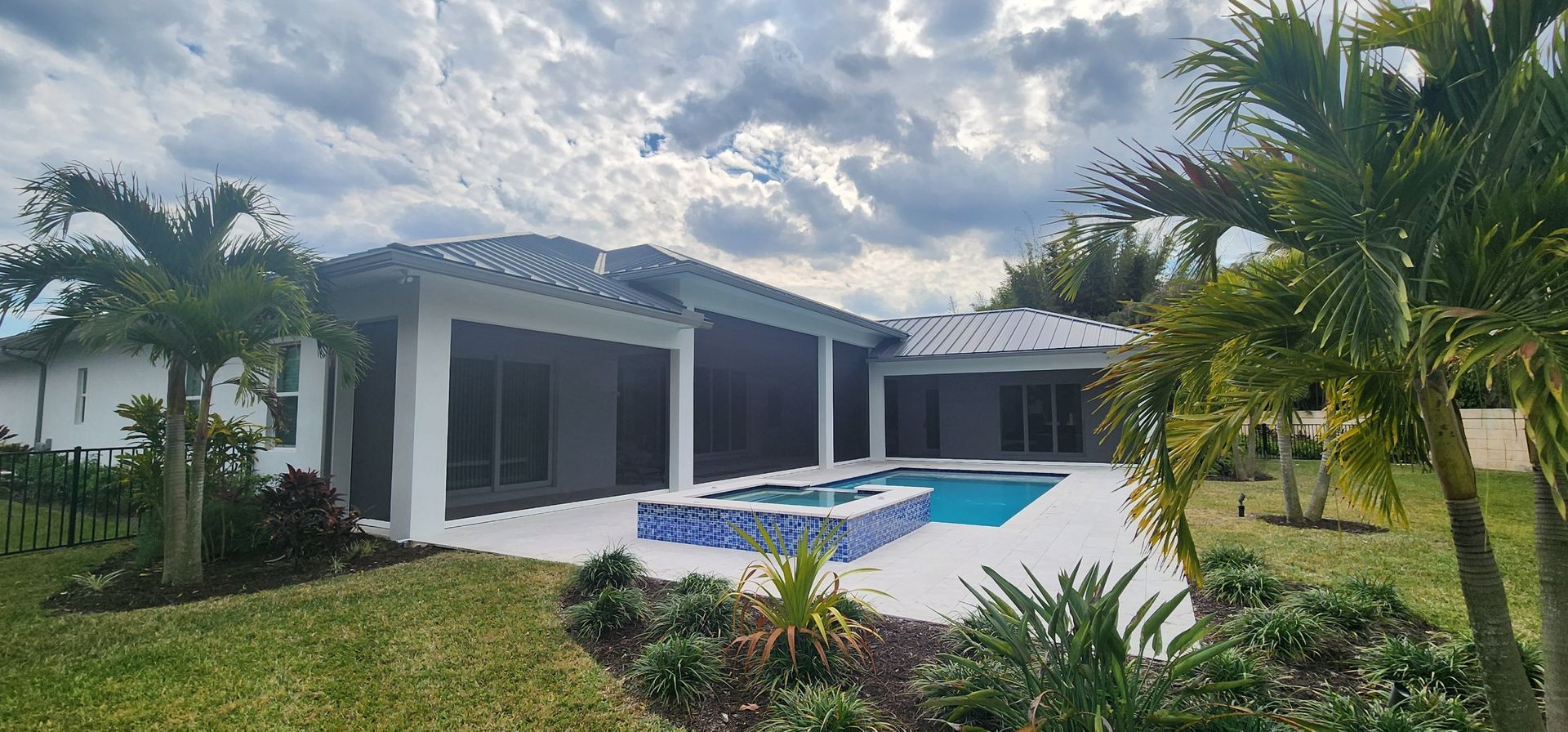 A house with a large swimming pool in front of it.