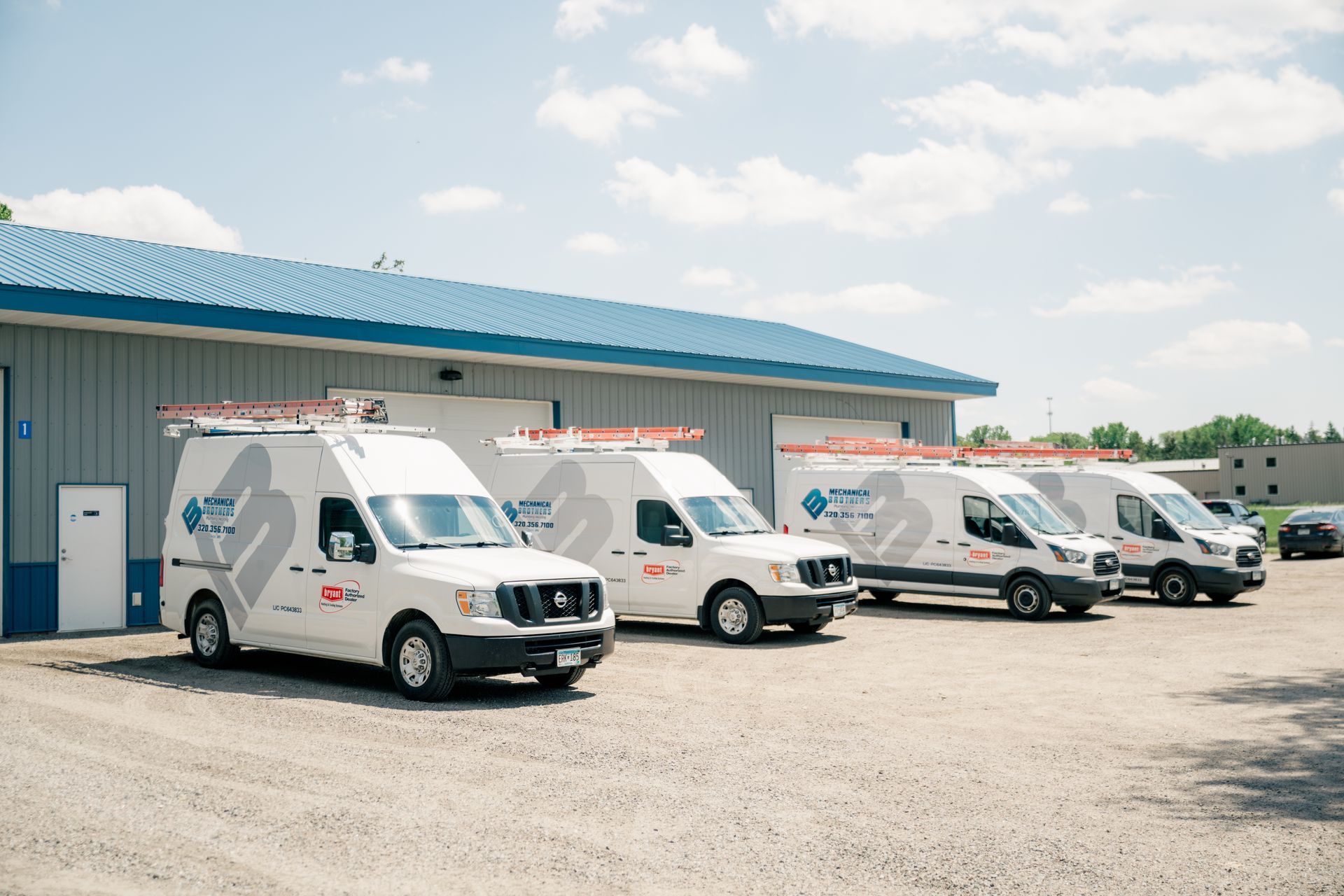 A row of white vans parked in front of a building.