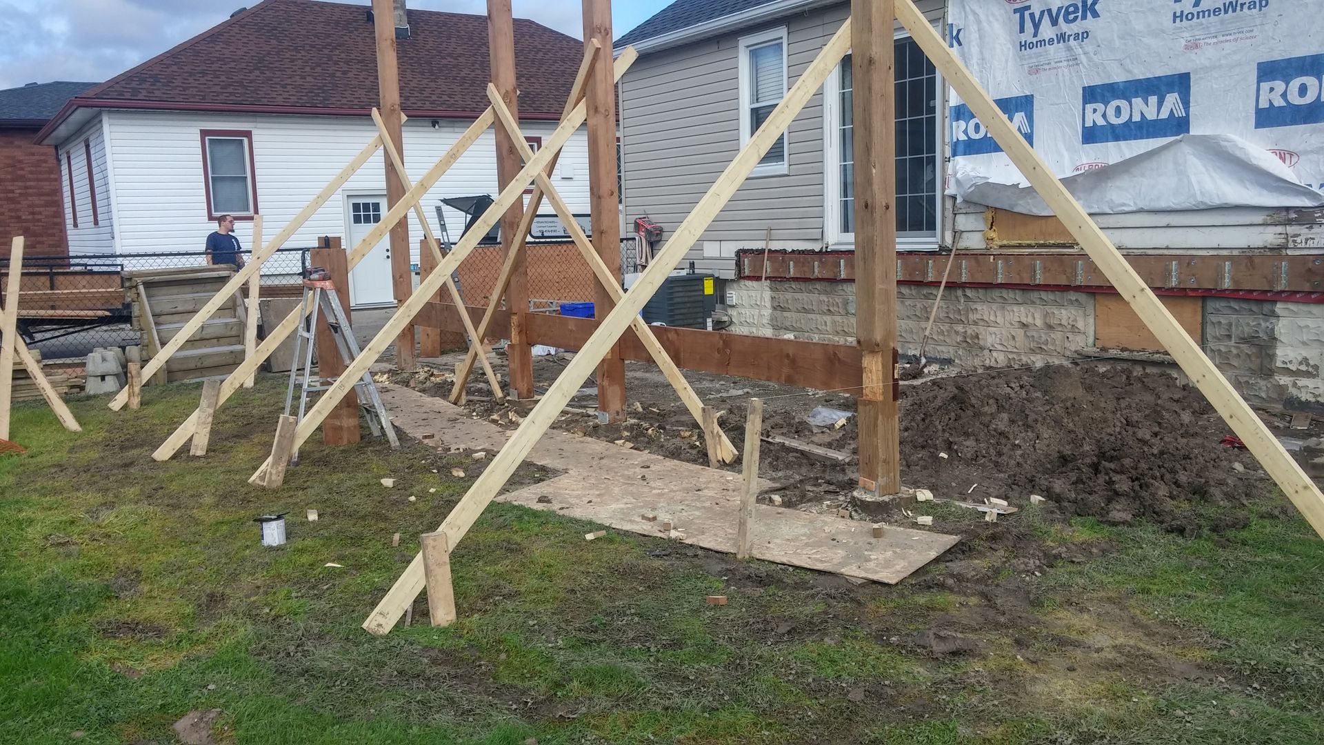 A wooden structure is being built in front of a house.