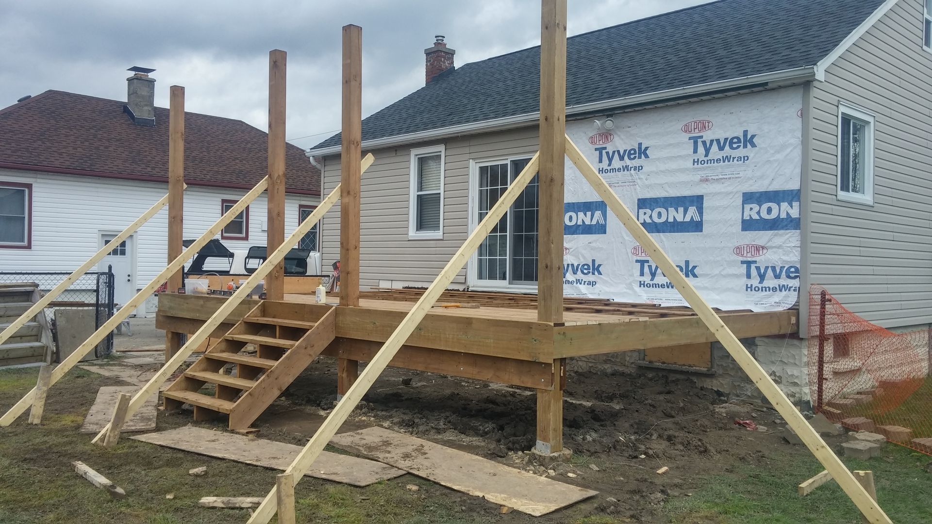 A wooden deck is being built in front of a house.