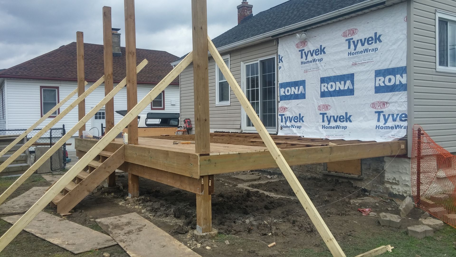 A wooden deck is being built in front of a house.