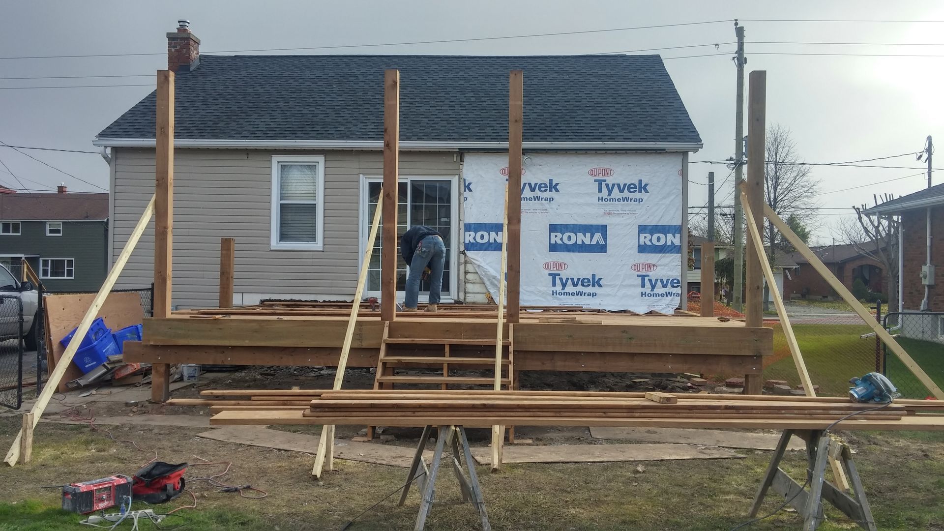 A house is being remodeled with a deck being built