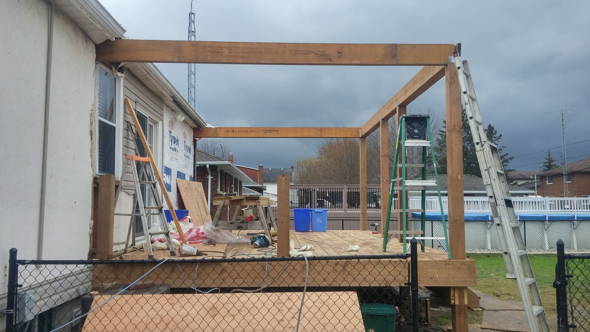 A wooden structure is being built on the side of a house