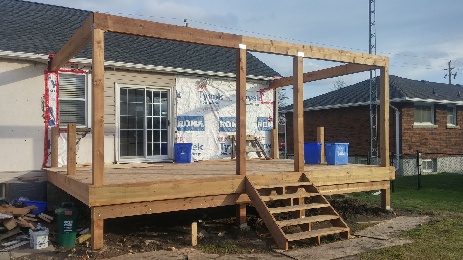A wooden deck is being built in front of a house.