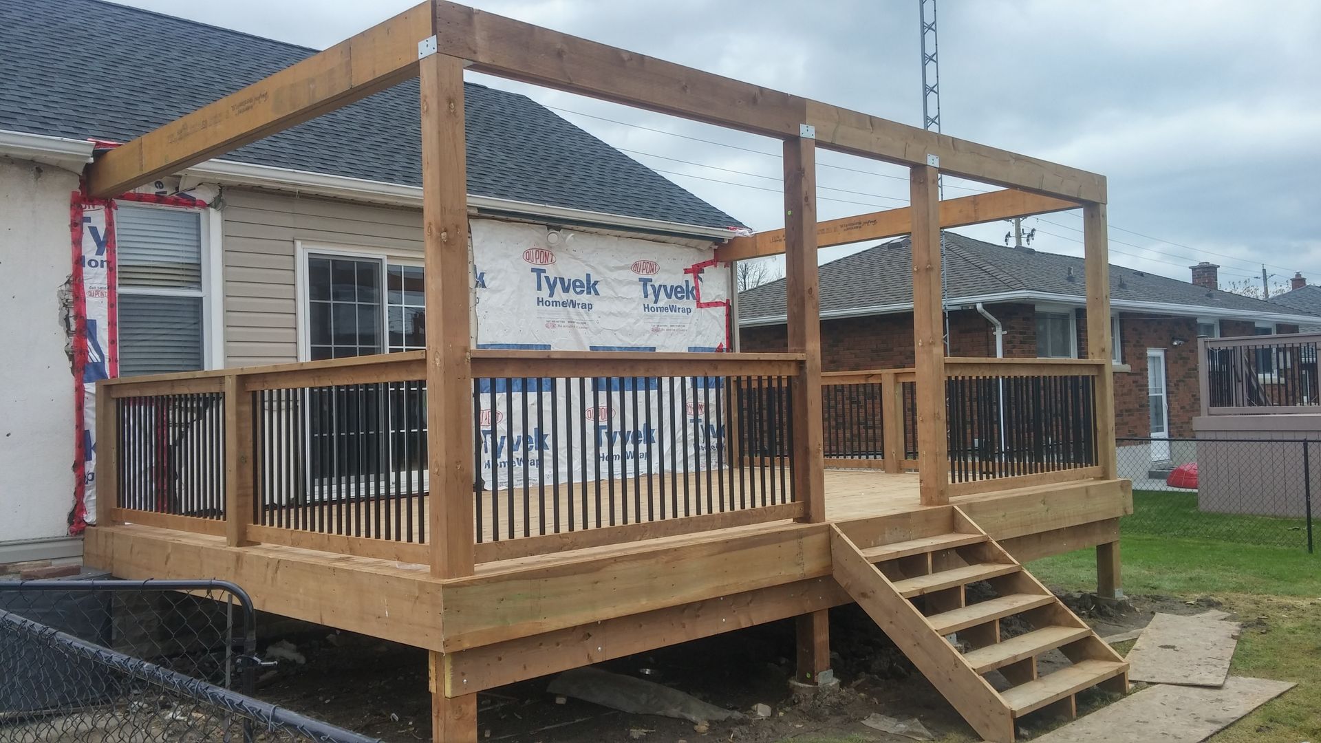 A wooden deck is being built in front of a house.