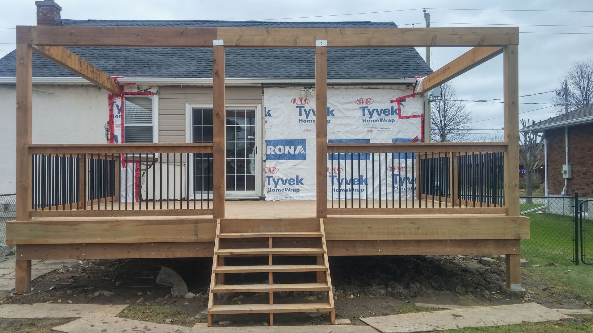 A wooden deck is being built in front of a house.
