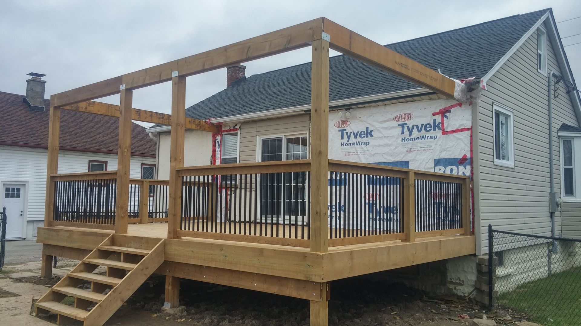 A wooden deck is being built on the side of a house.
