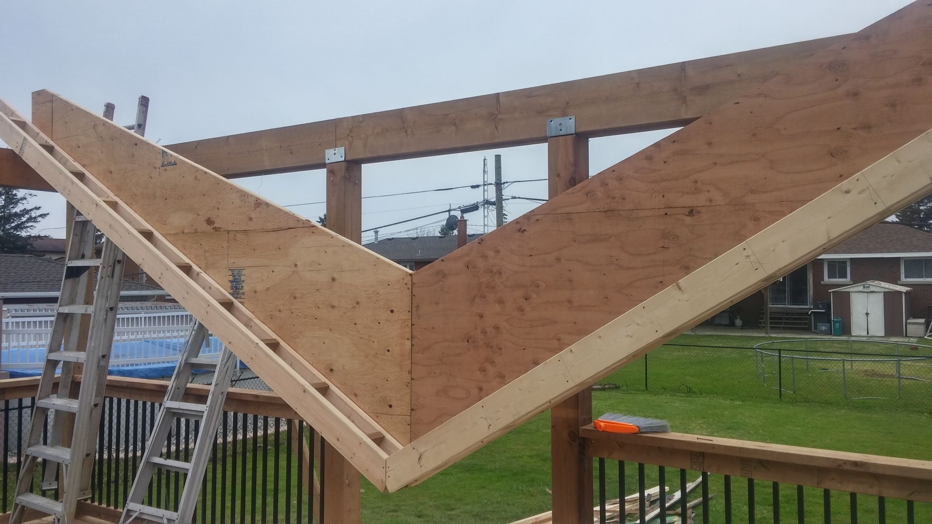 A wooden structure is being built with a ladder in the foreground