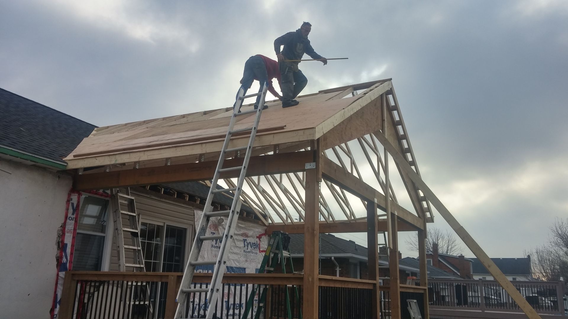 Two men are working on the roof of a house.
