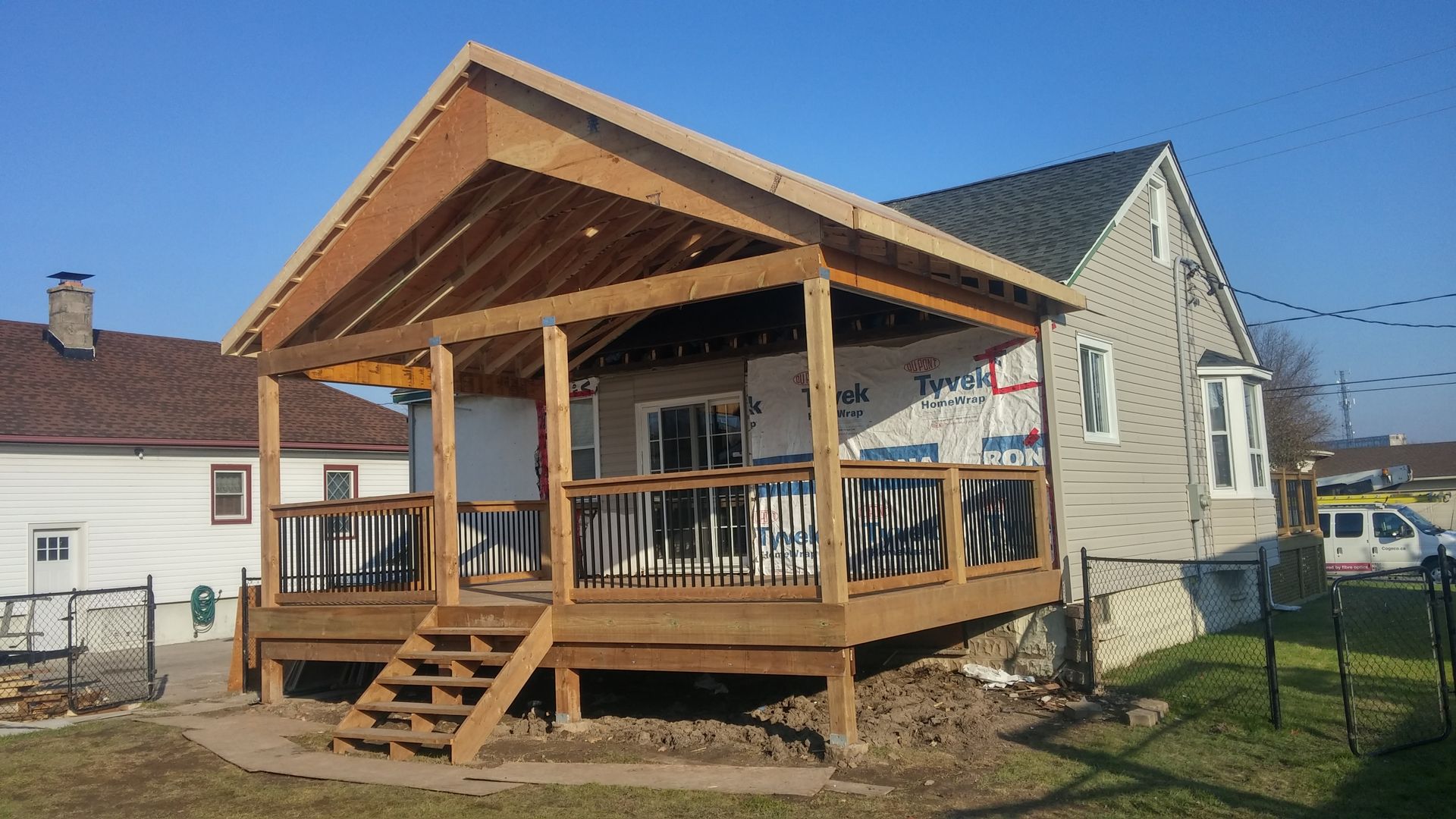 A wooden deck is being built on the side of a house.