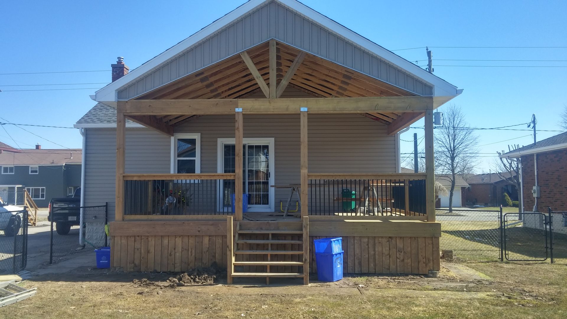 A house with a wooden porch and stairs in front of it.