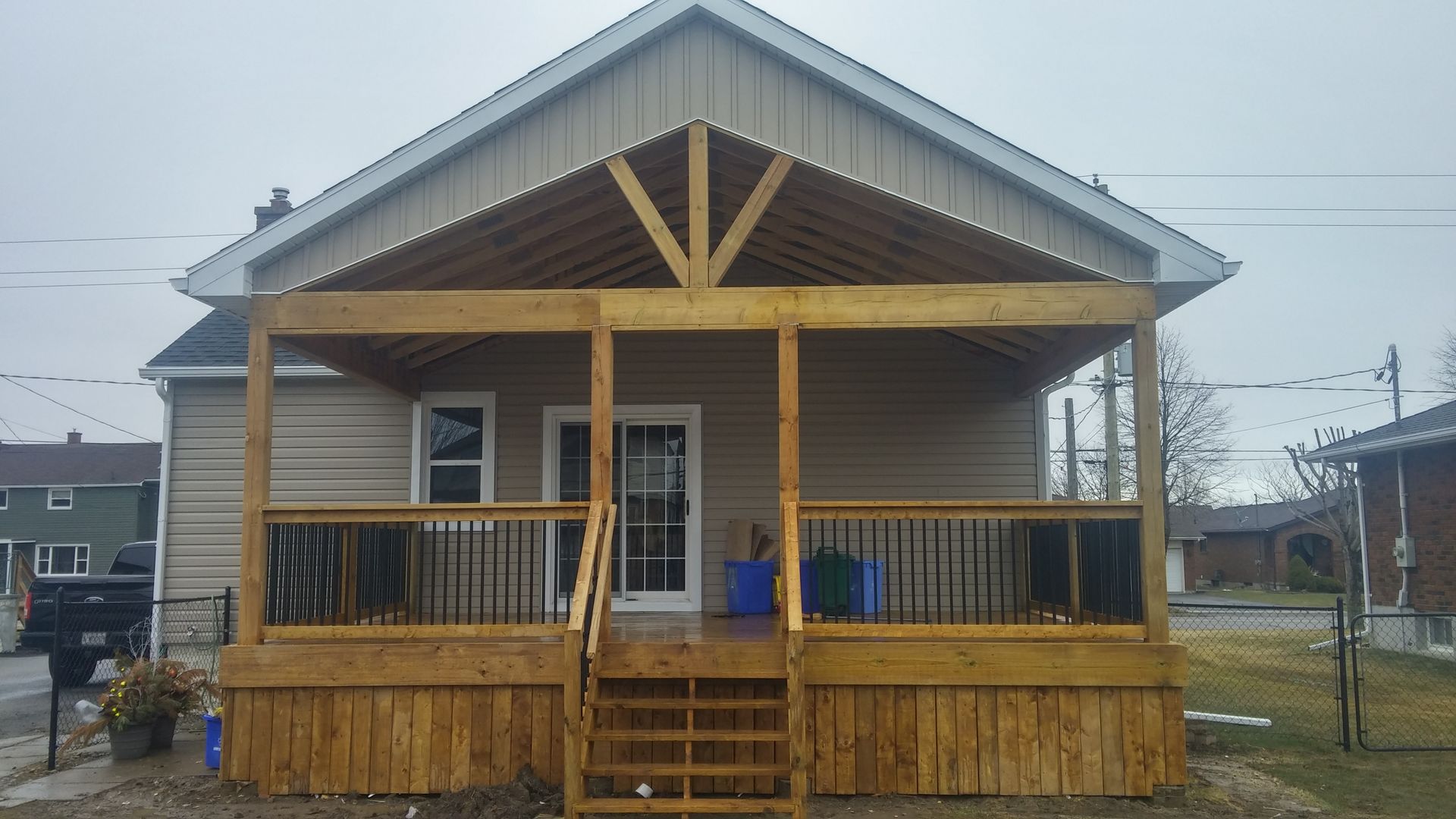 A house with a wooden porch and stairs in front of it.
