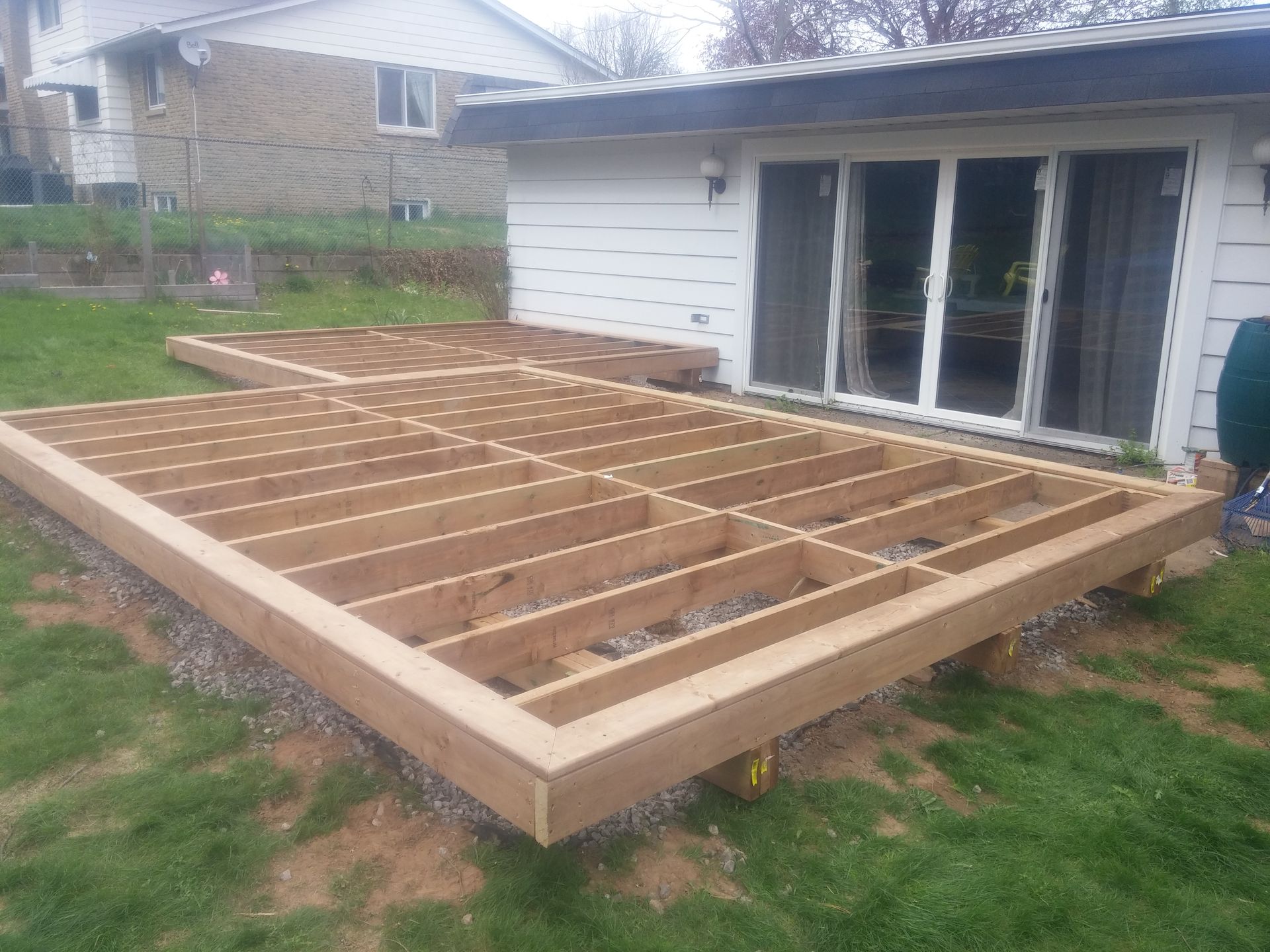 A wooden deck is being built in front of a house.