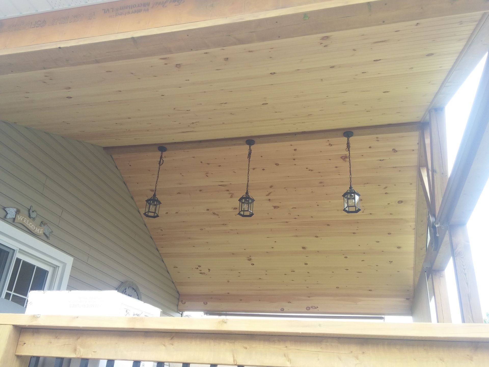 A wooden deck with lanterns hanging from the ceiling