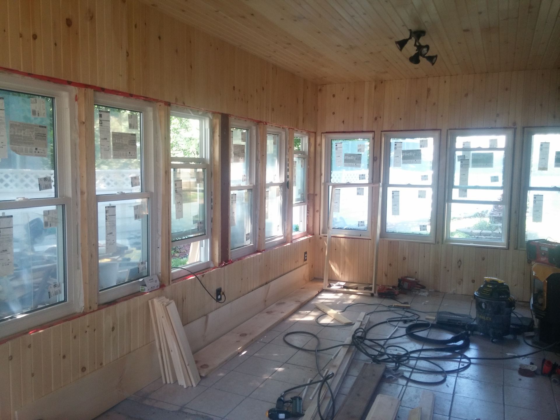 A room with a lot of windows and wooden walls