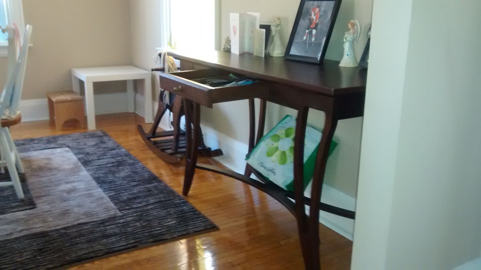 A room with a wooden table and chairs and a rug.