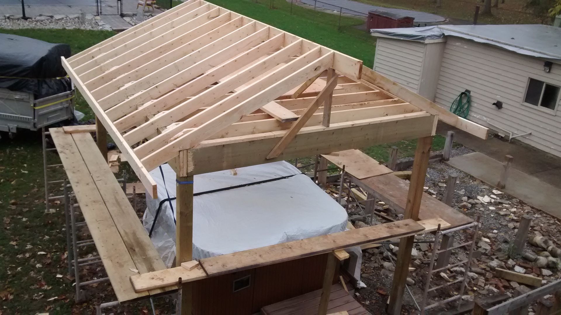 A wooden structure is being built over a hot tub.