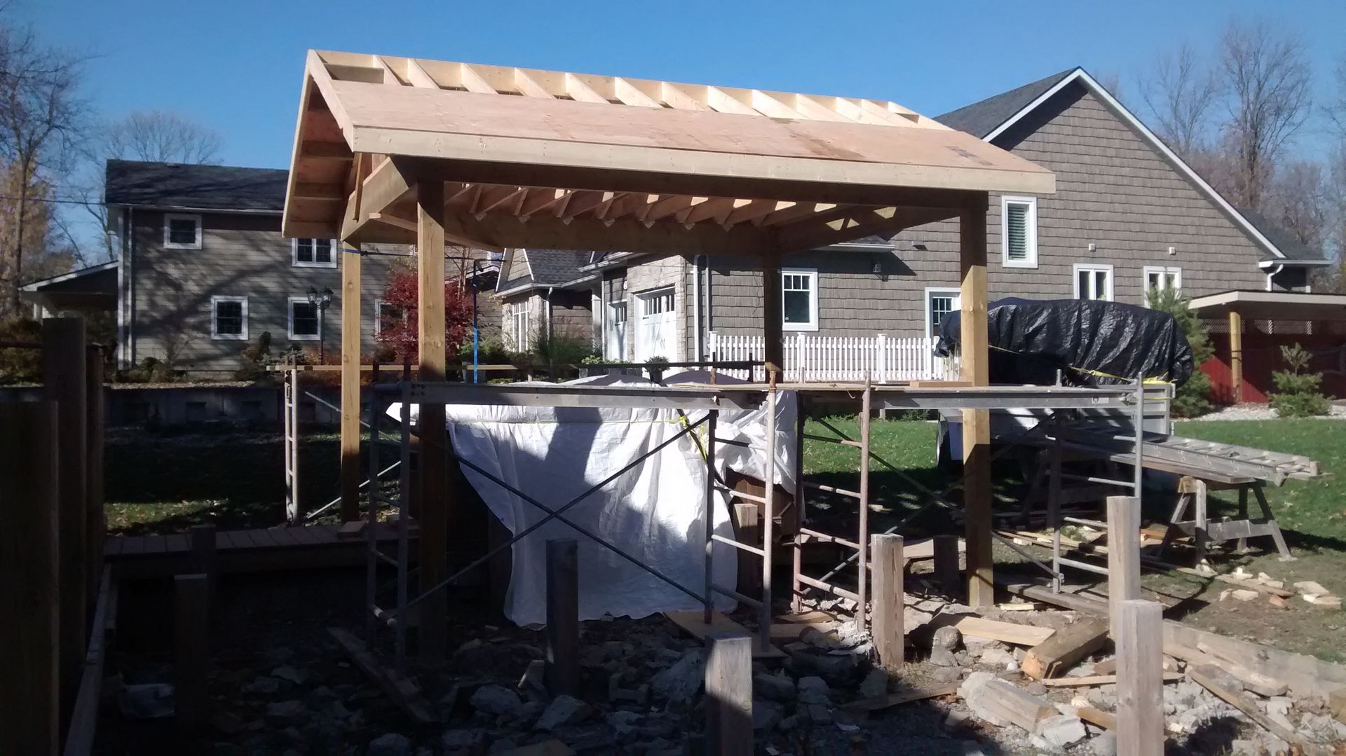 A wooden structure is being built in front of a house.