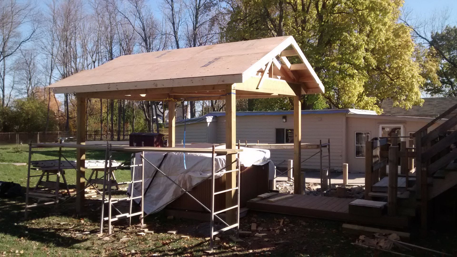 A wooden structure is being built in a backyard