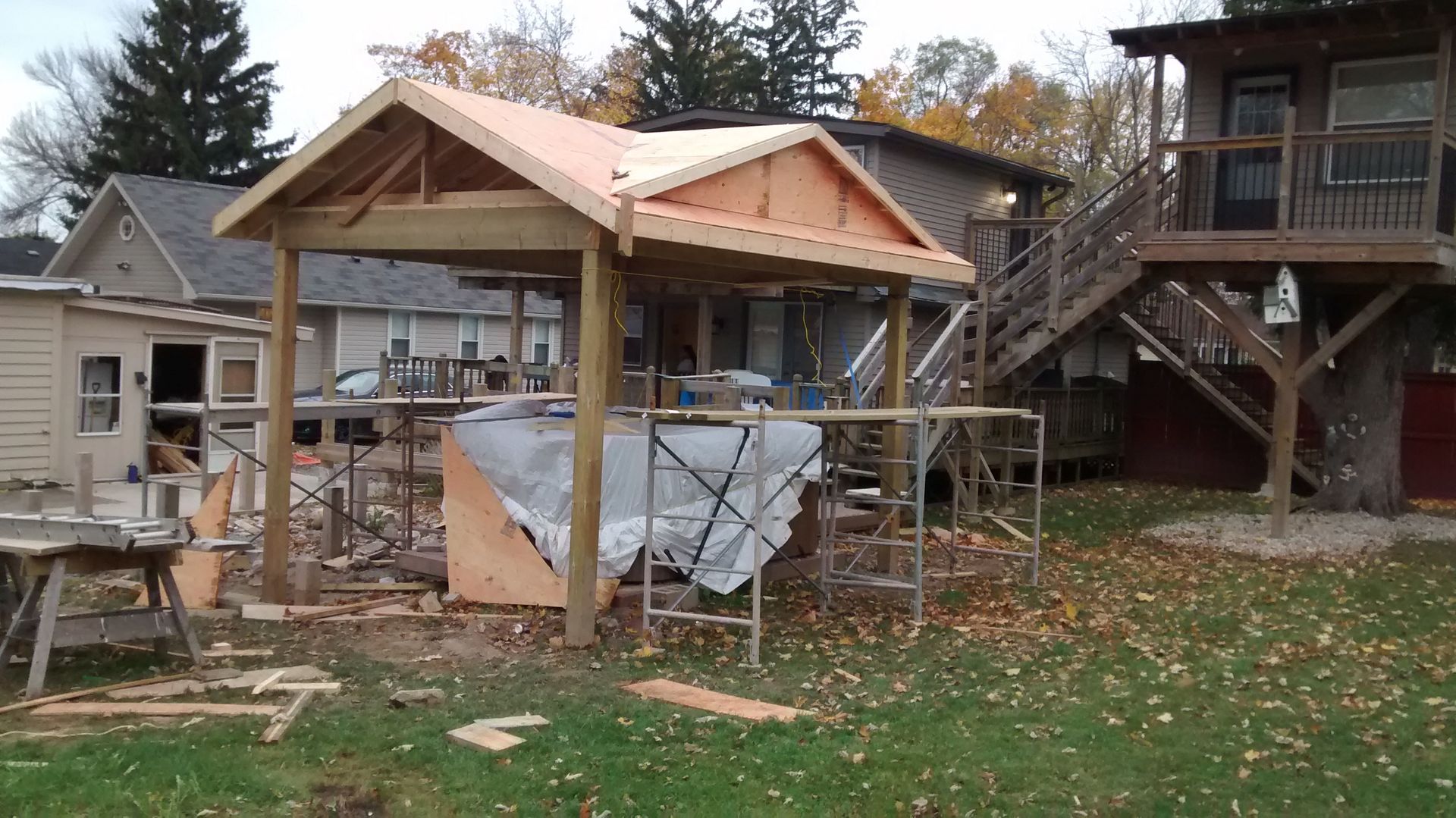 A wooden structure is being built in front of a house