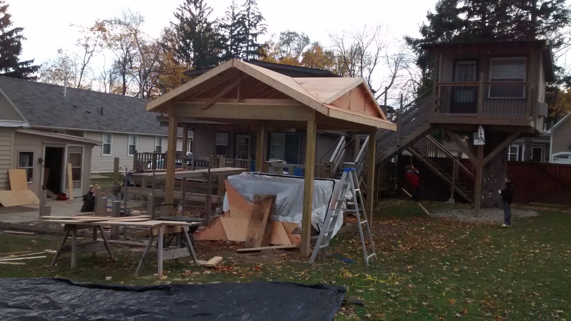 A house under construction with a tree house in the background