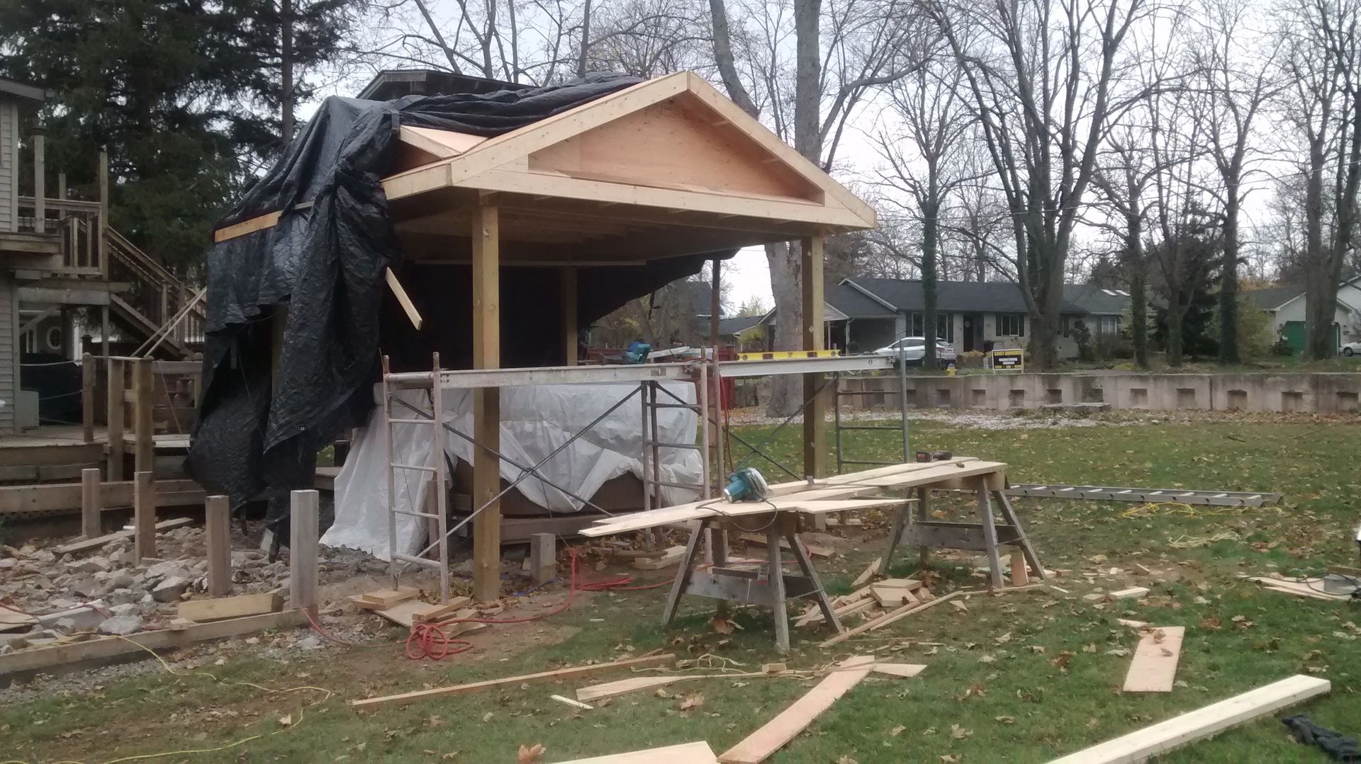 A wooden structure is being built in a backyard.