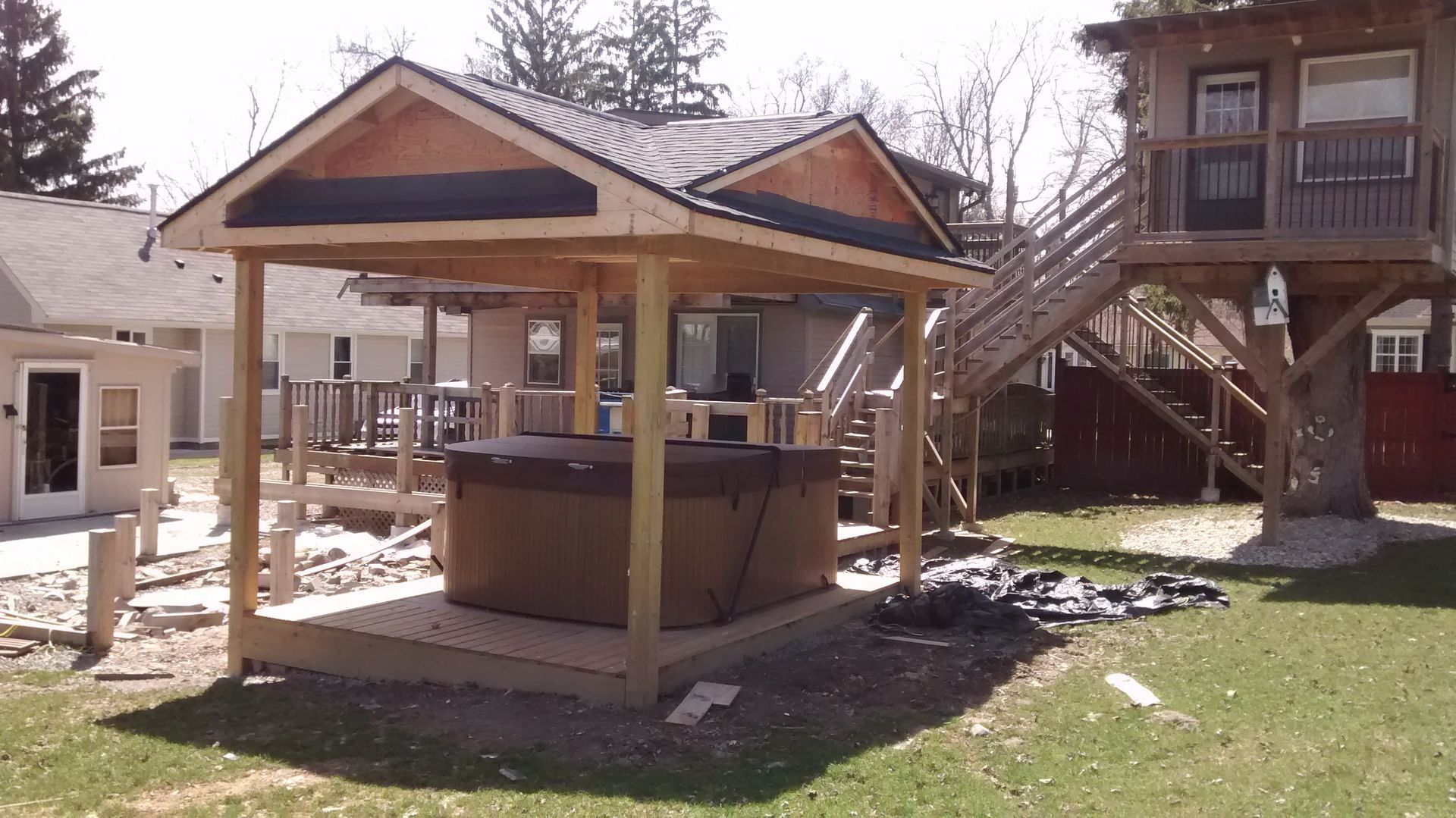 A gazebo is being built in the backyard of a house