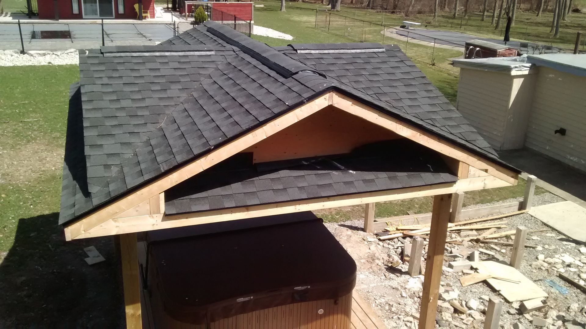 A hot tub is under a roof that is being built