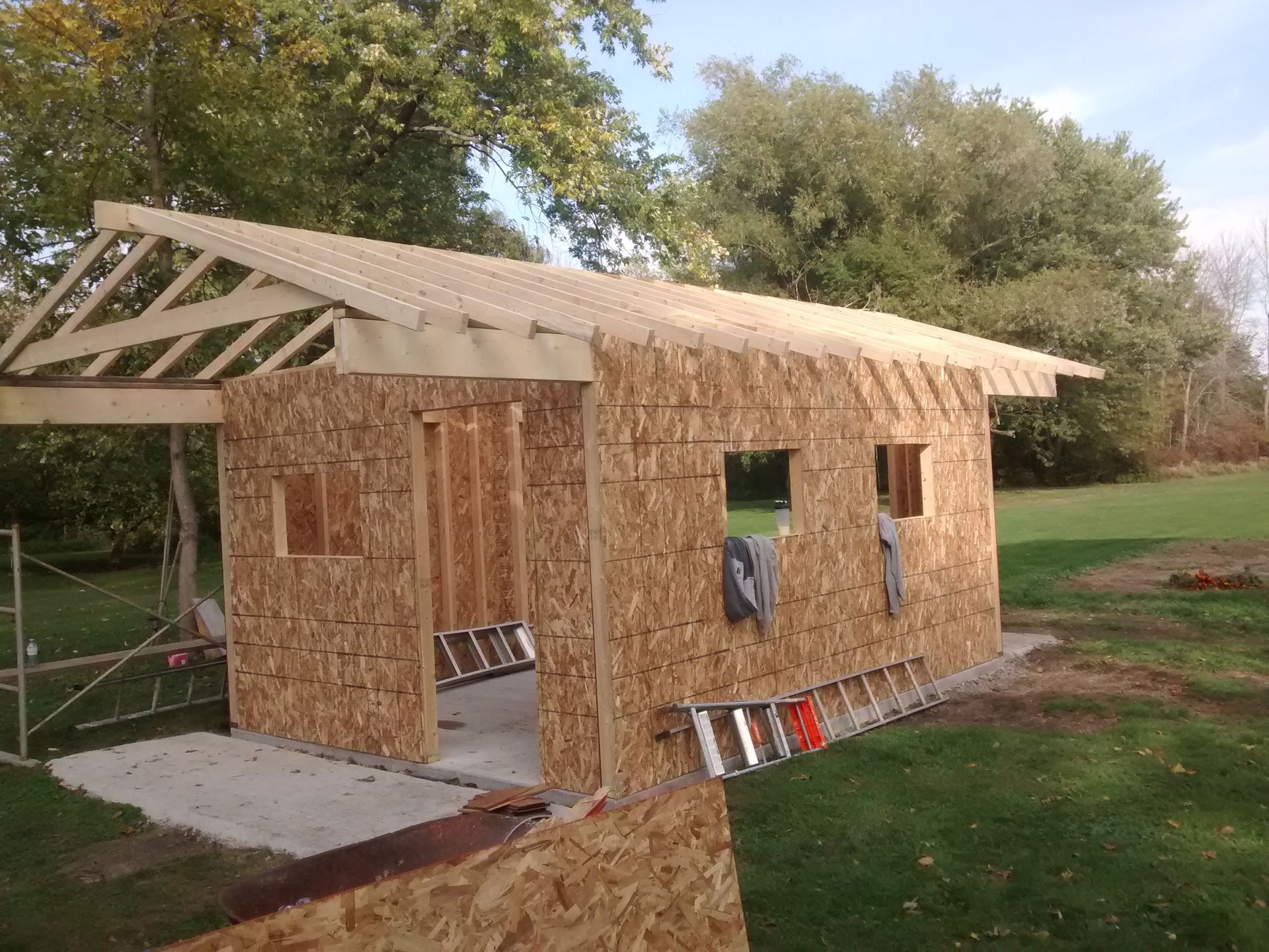 A wooden shed is being built in a backyard.