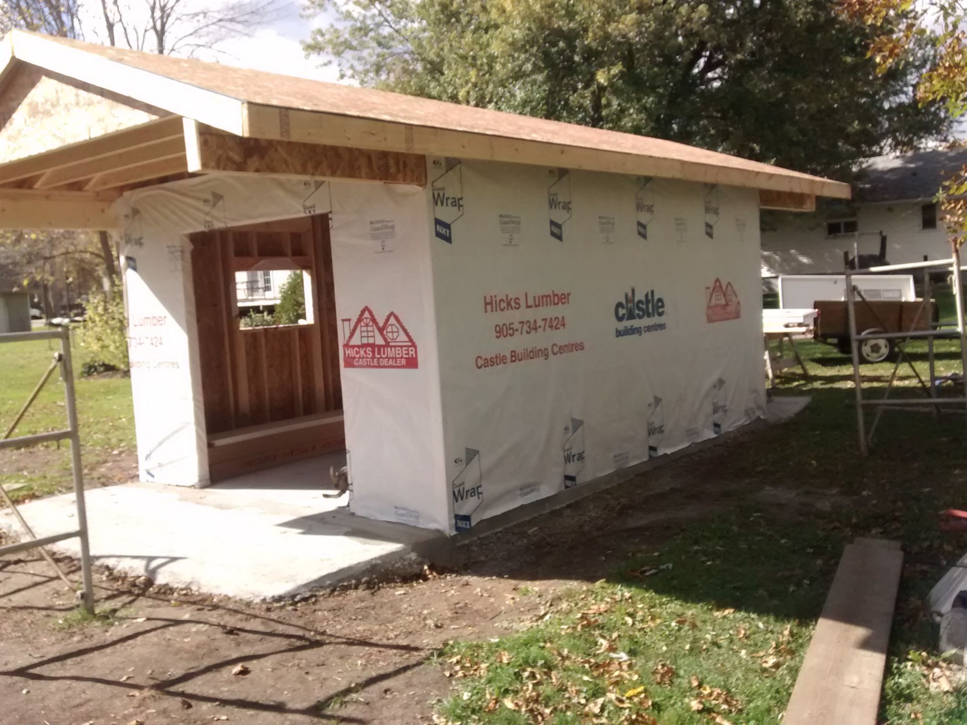 A shed is being built in a backyard with a roof