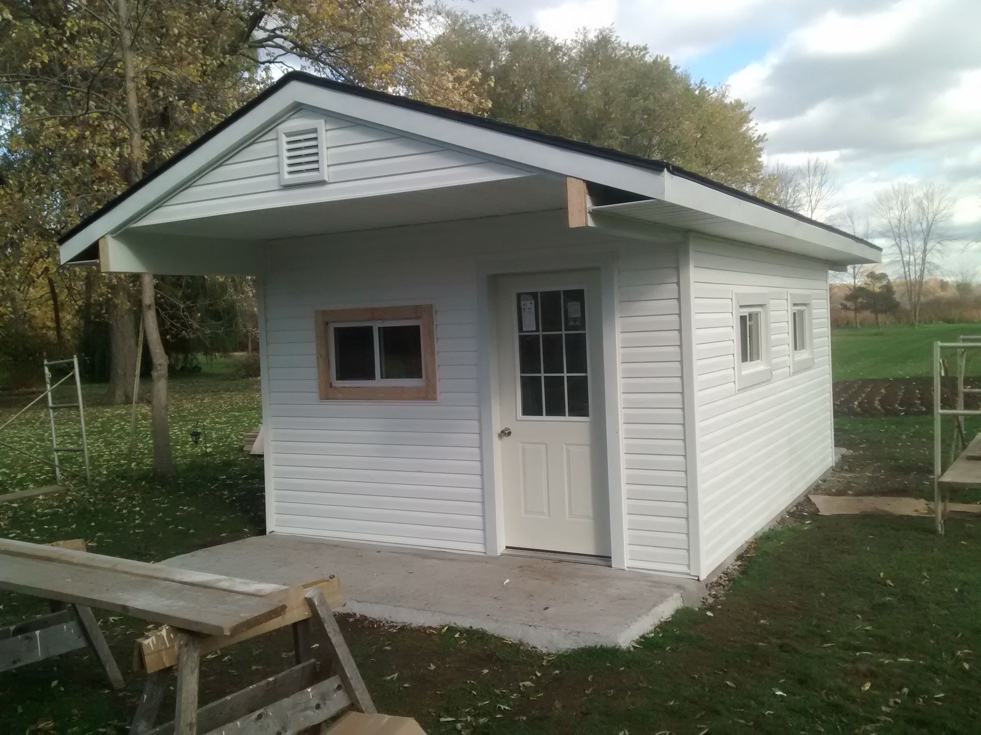 A small white house with a black roof and a window