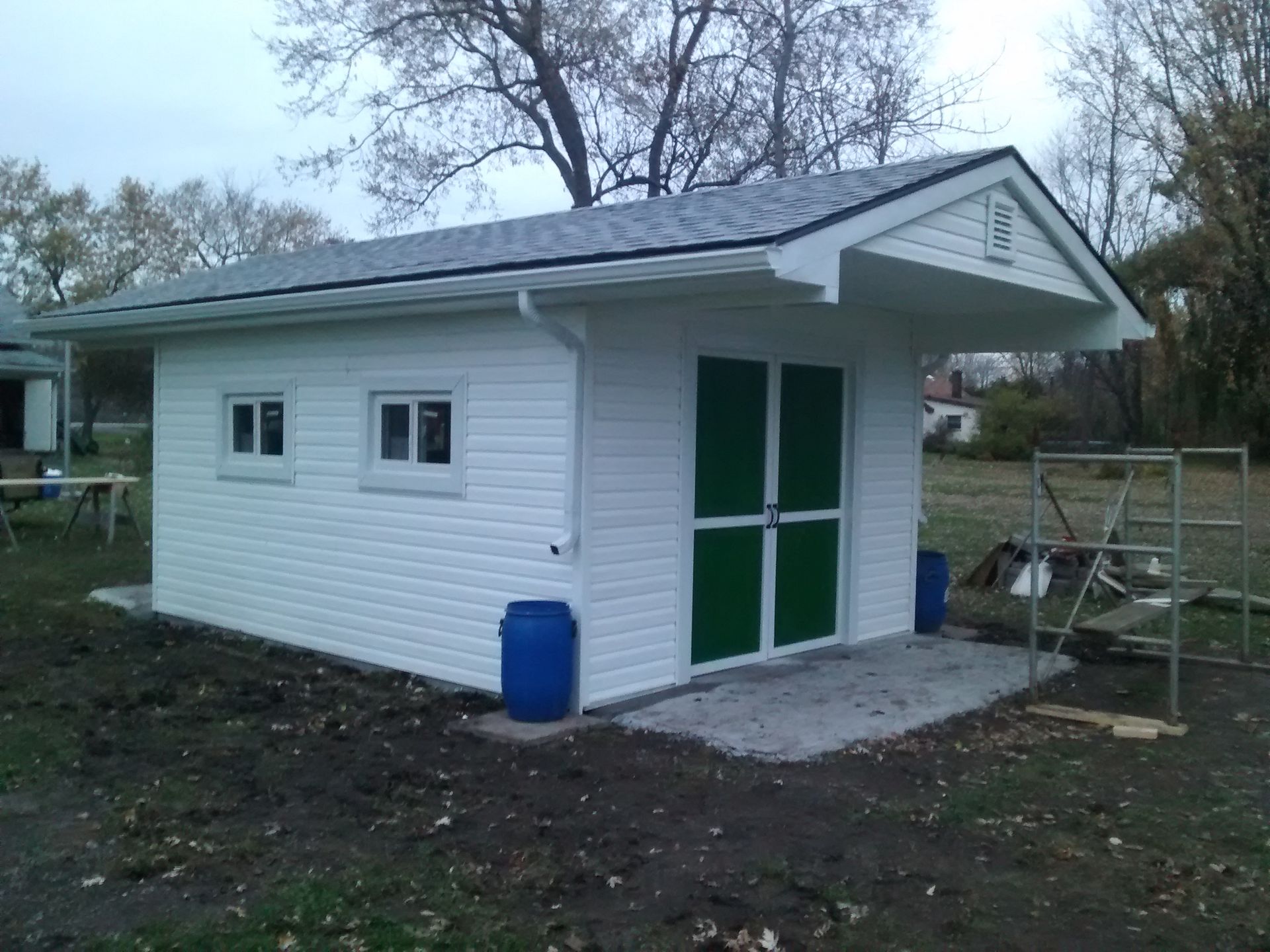 A small white building with green doors and windows