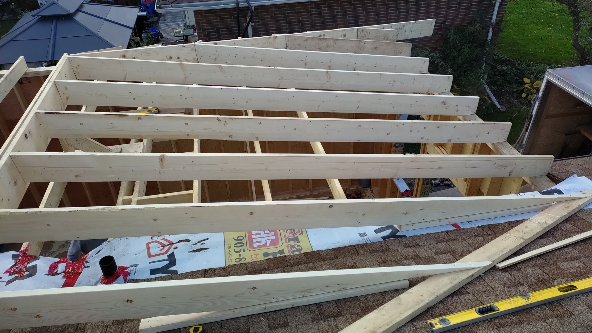 A wooden structure is being built on the roof of a house.