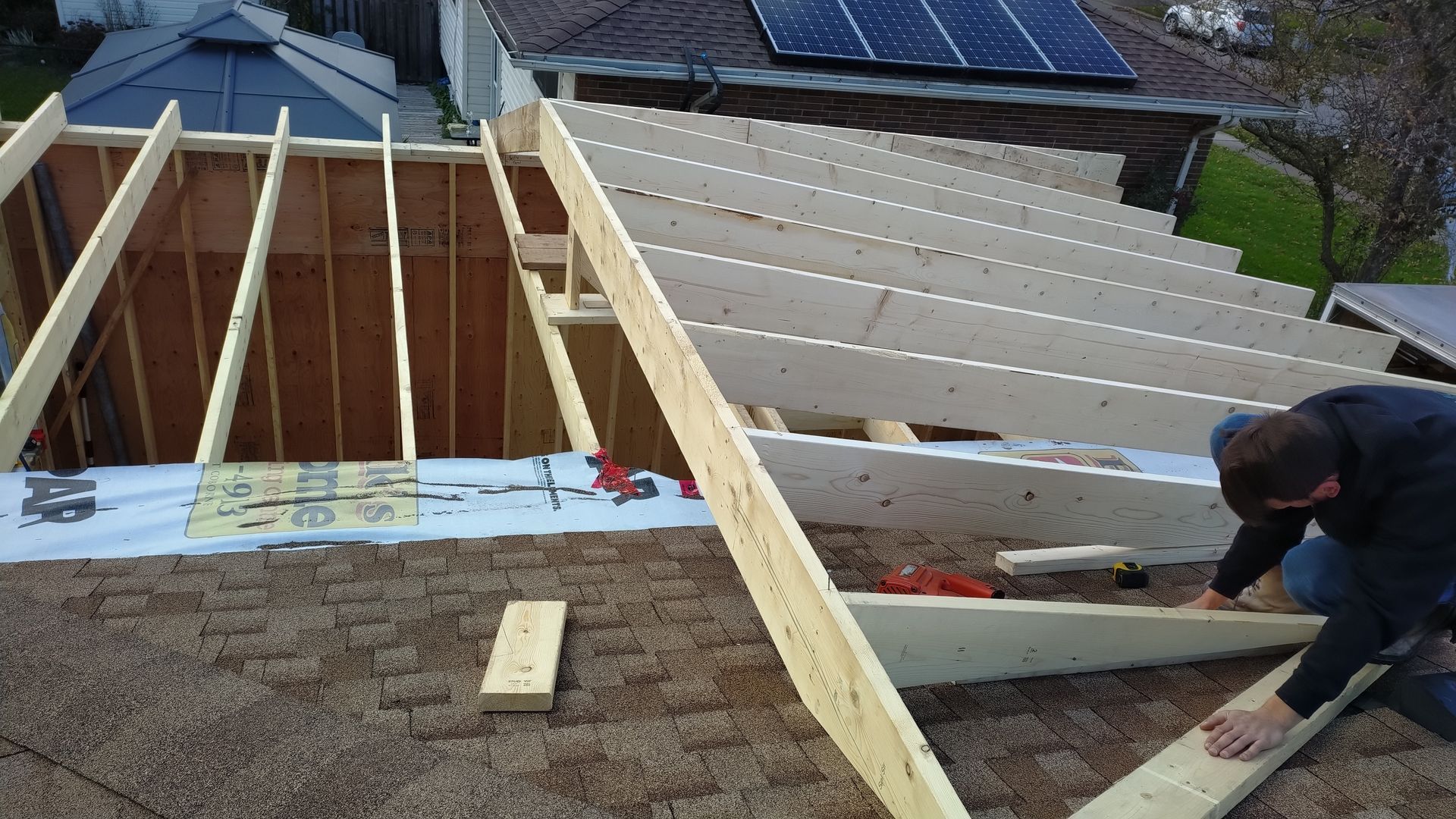 A man is working on the roof of a house