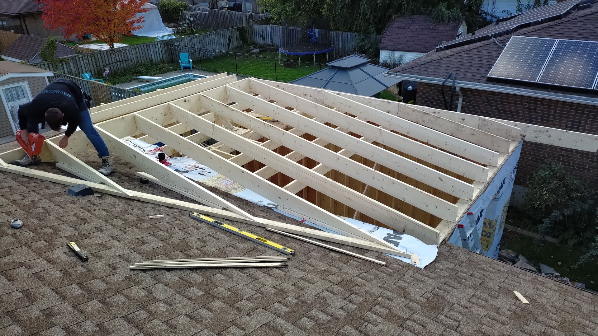 A man is working on the roof of a house.