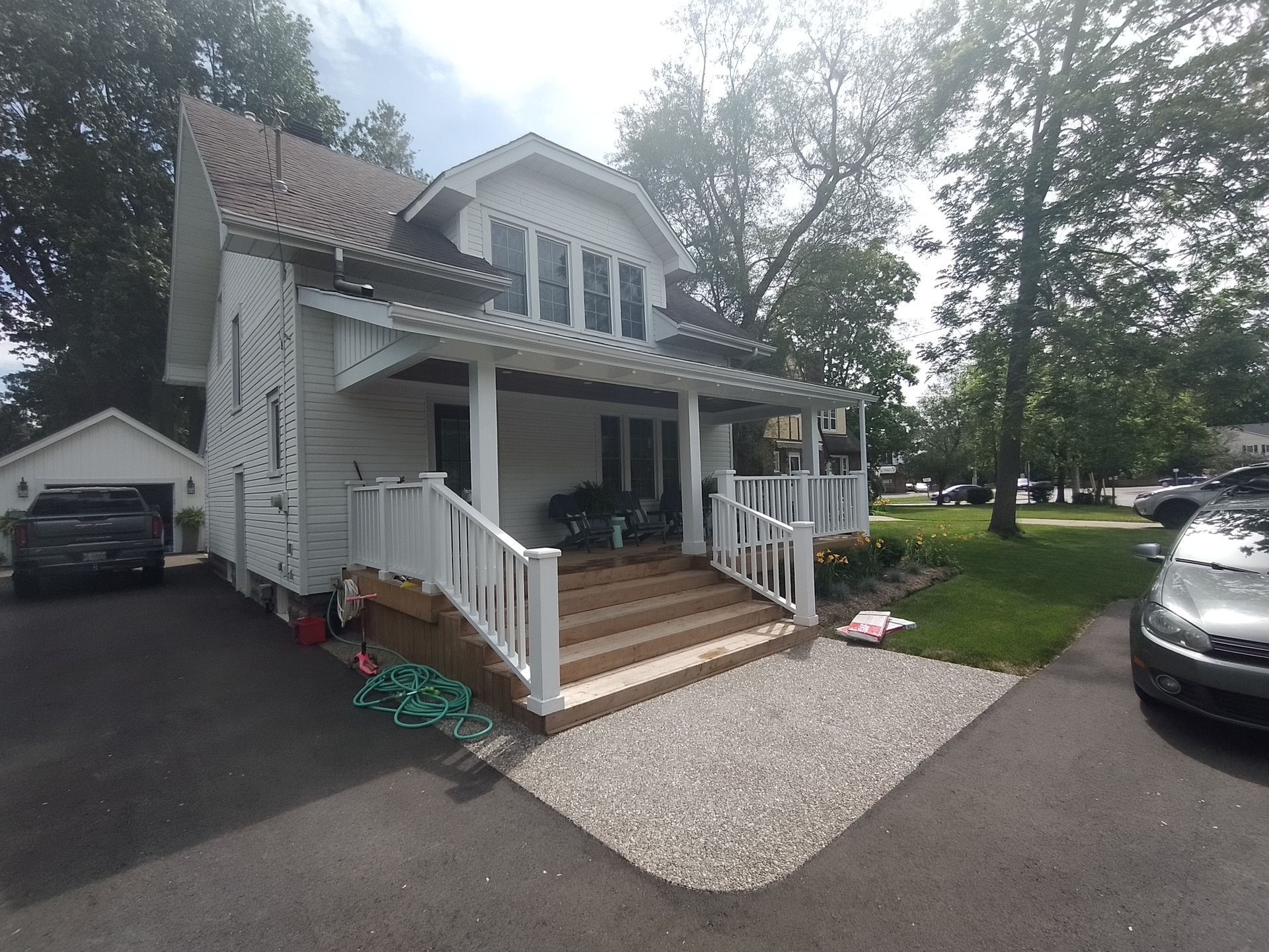 A white house with a car parked in front of it