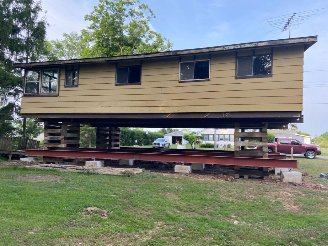 A house is being moved into a new location on stilts.