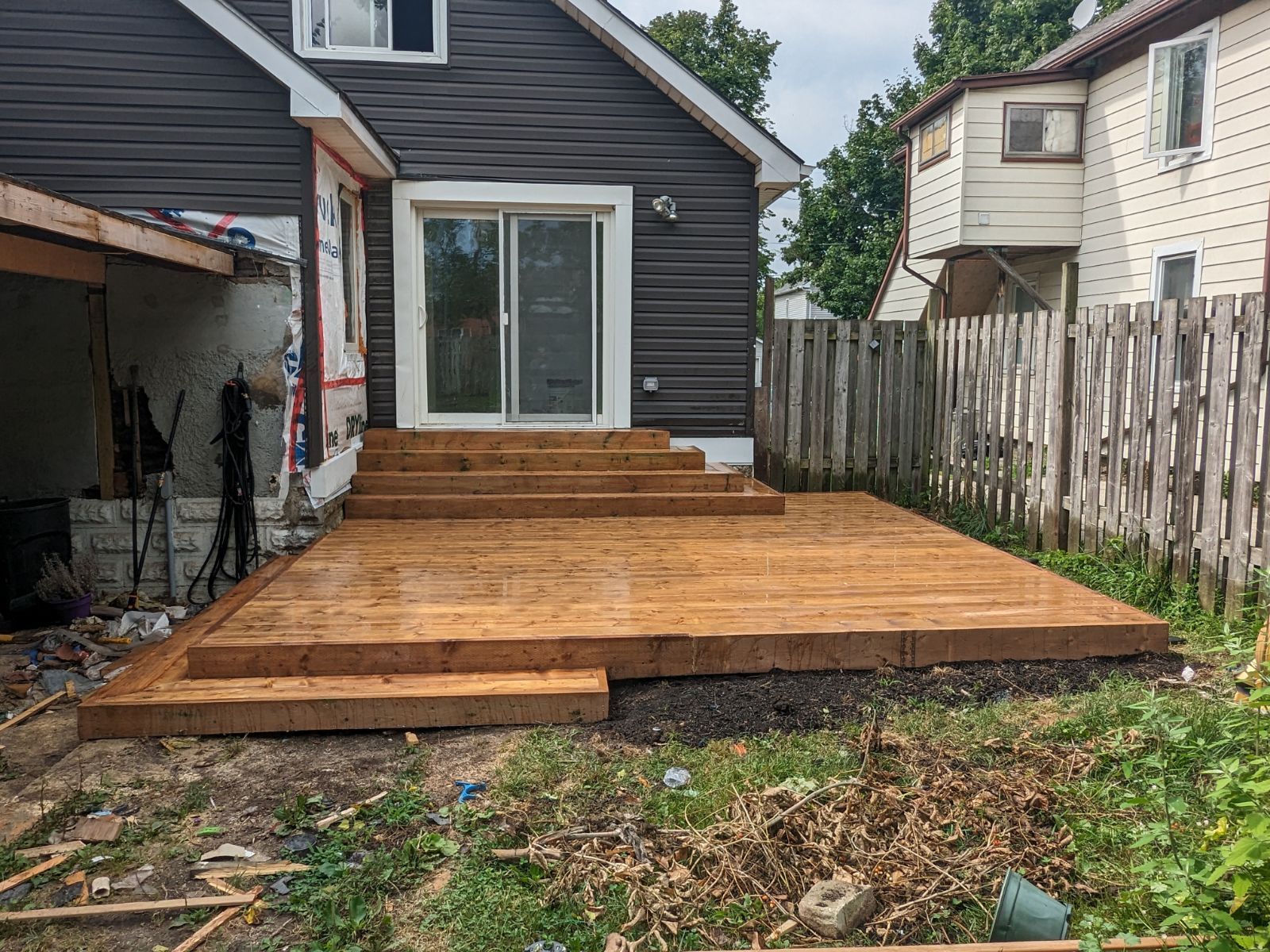 A wooden deck is being built in the backyard of a house.