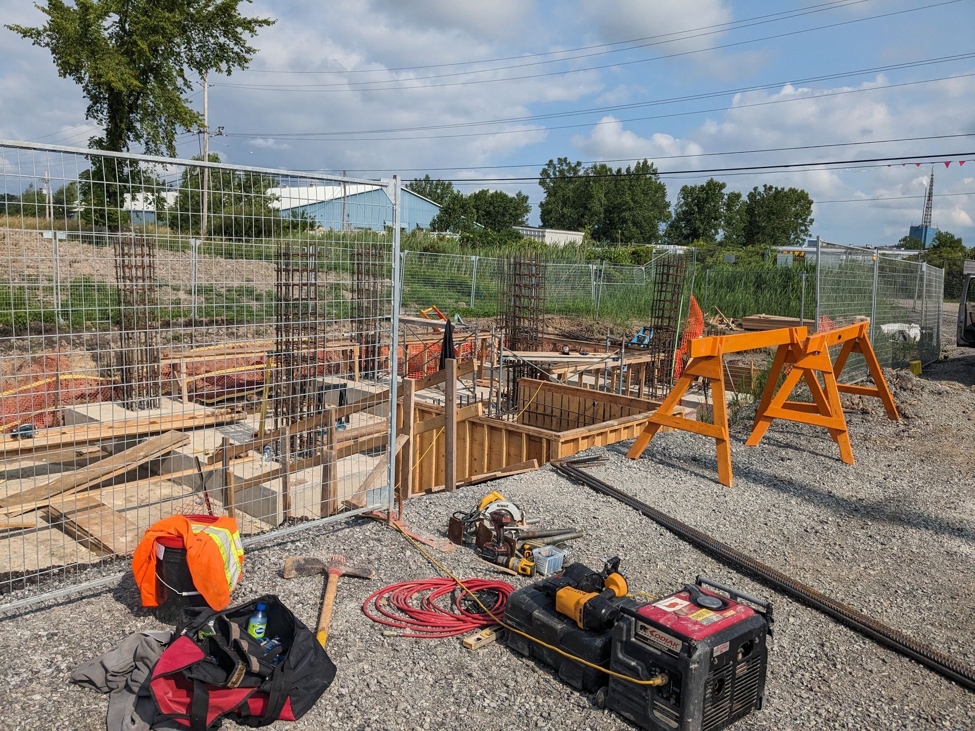 A construction site with tools and a generator on the ground.