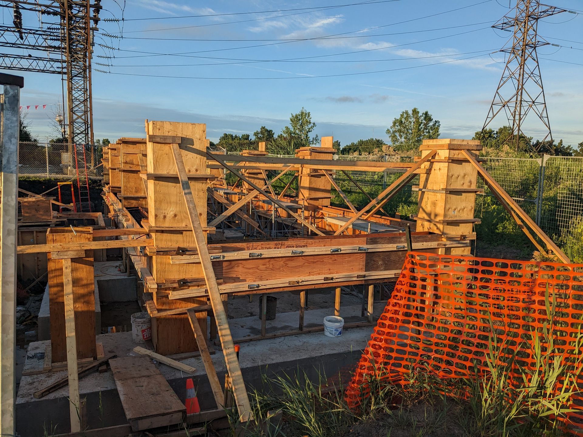 A construction site with a fence and a crane in the background