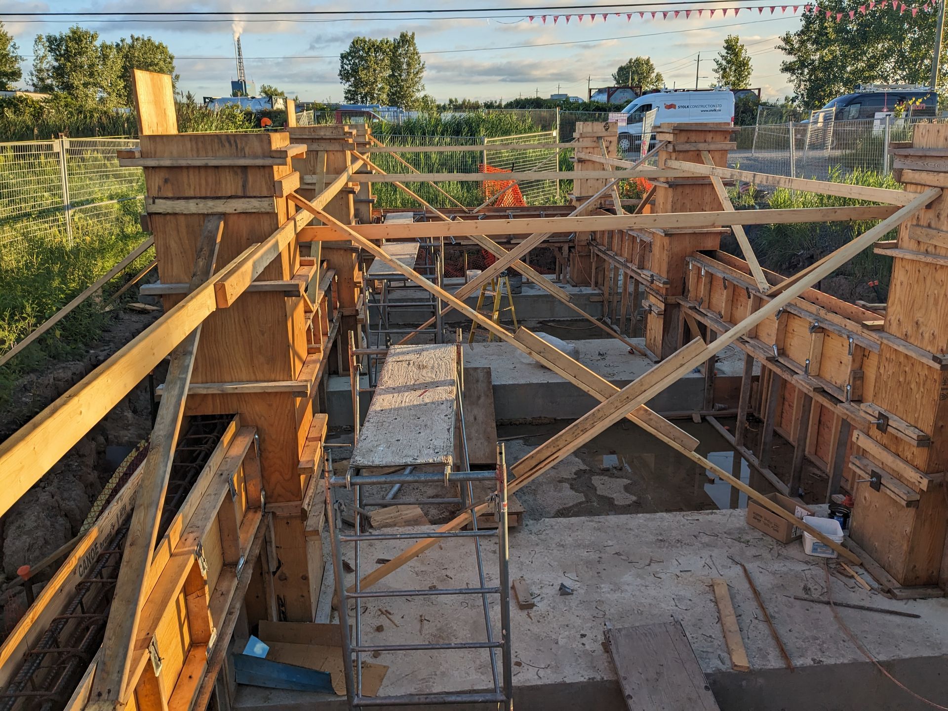 A construction site with wooden scaffolding and a ladder.