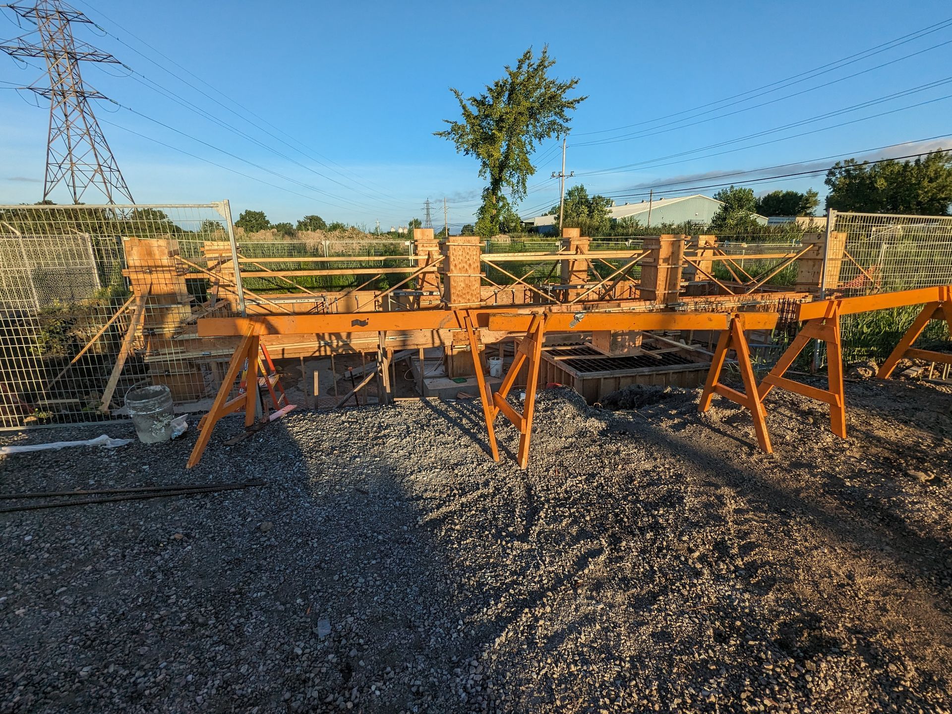 A construction site with a lot of bricks and wooden trestles.