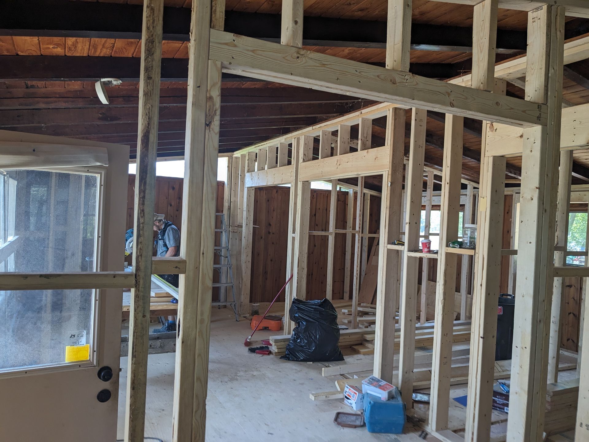 A house is being built with wooden beams and a door.