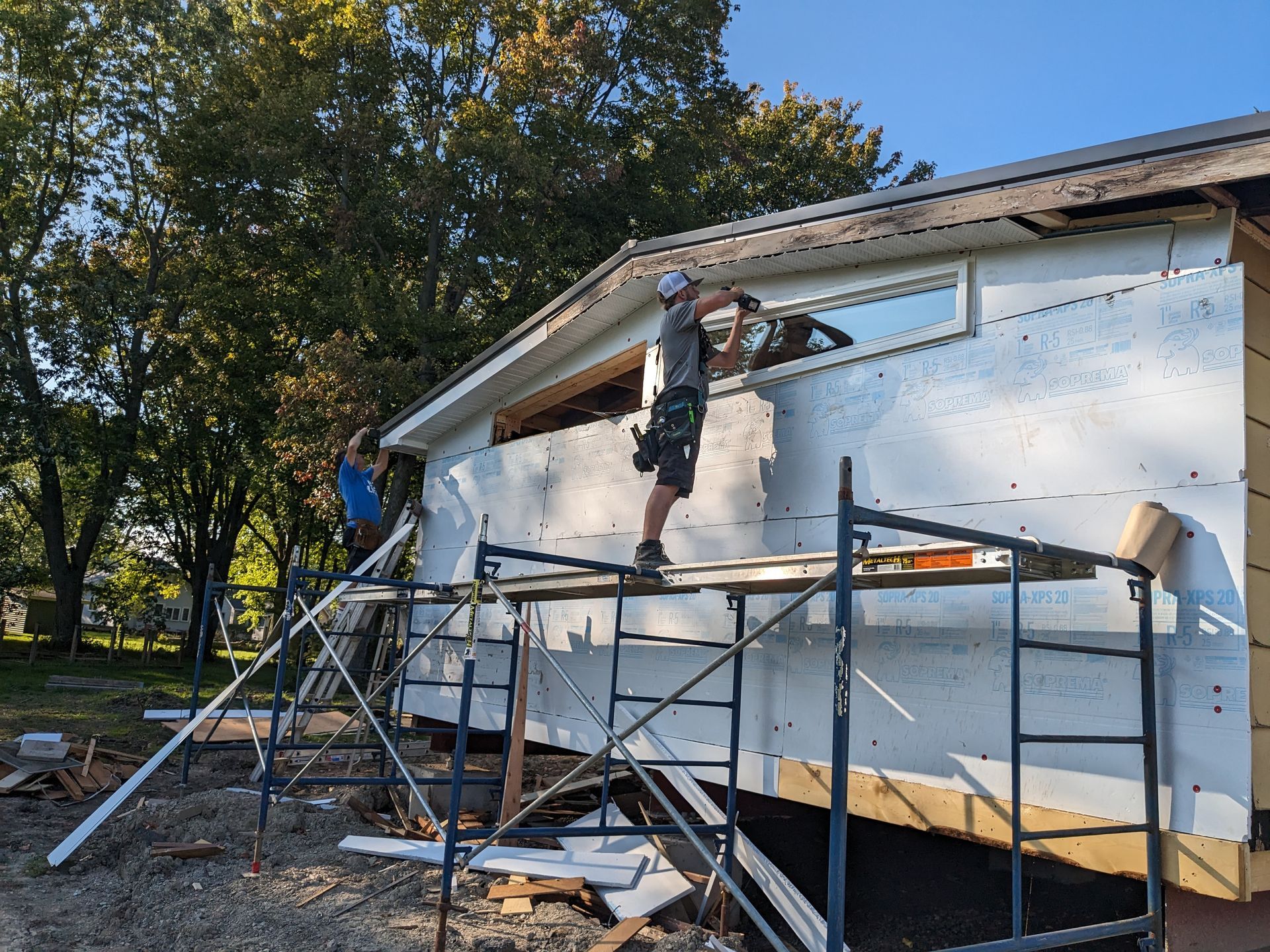 A man is standing on a scaffolding on the side of a building.