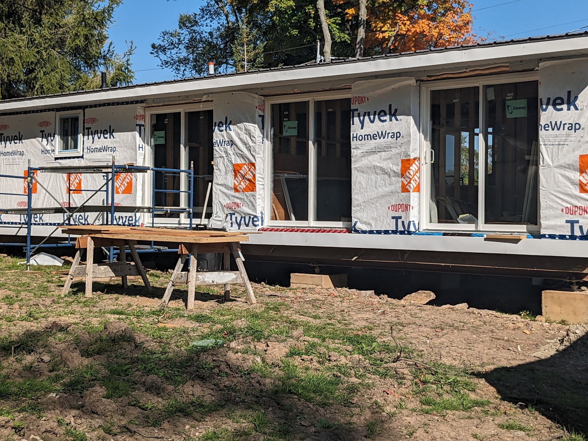 A house is being built in a field with a table in front of it.