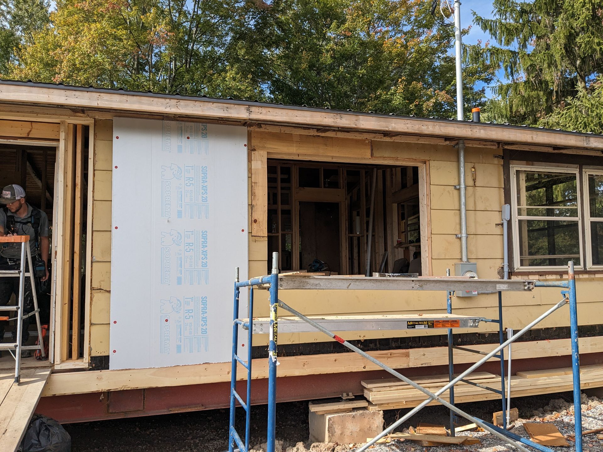 A man is standing in front of a house under construction.