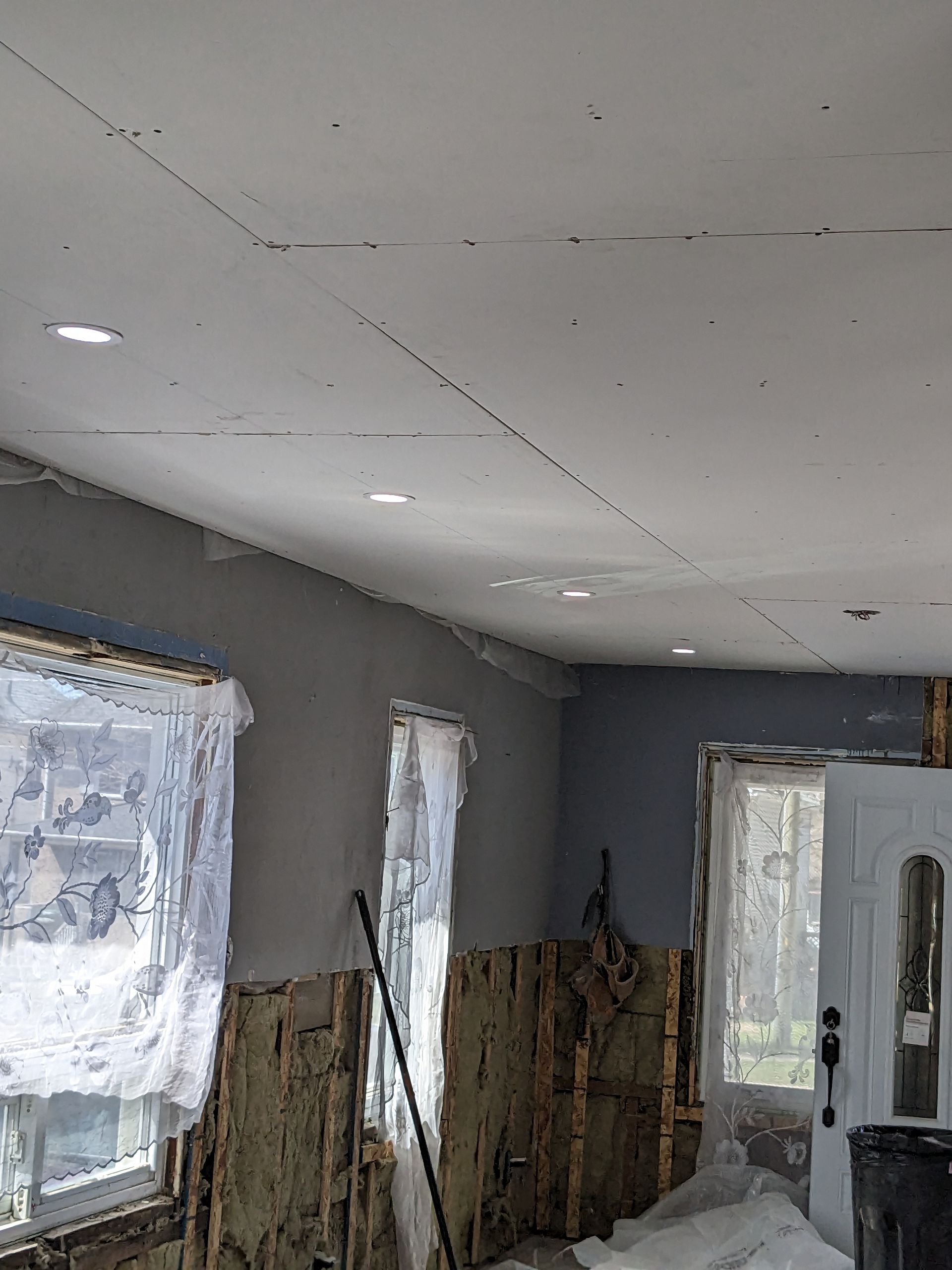 A room with a lot of windows and a ceiling that is being remodeled.